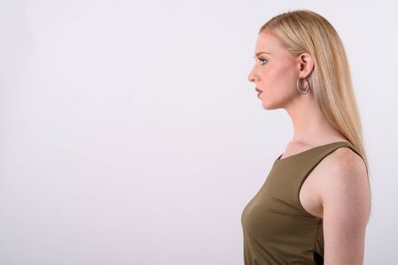 Young beautiful British woman with blond hair against white backgroundの写真素材