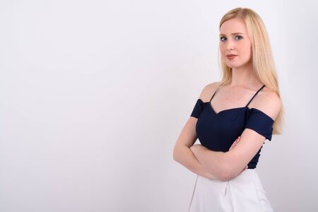 Young beautiful British woman with blond hair against white backgroundの写真素材