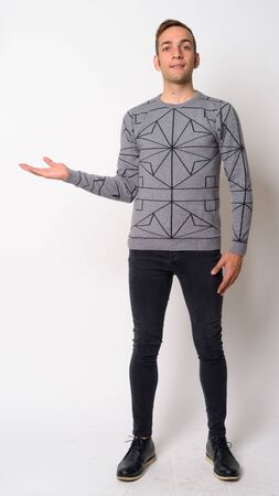 Full body shot of happy young Persian man showing somethingの写真素材