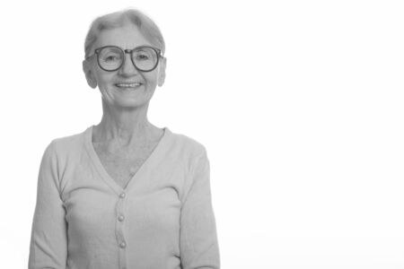 Studio shot of happy senior nerd woman smiling while wearing geeky eyeglasses