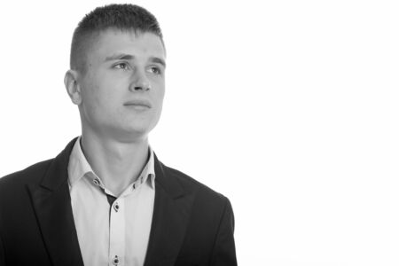 Studio shot of young businessman thinking in black and whiteの写真素材