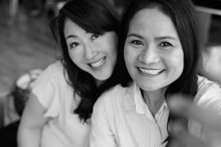 Personal point of view of two woman taking selfie in black and whiteの写真素材
