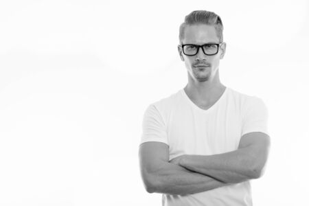 Studio shot of young handsome man wearing eyeglasses with arms crossedの写真素材
