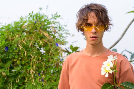 Young handsome rebellious man outdoors wearing glasses