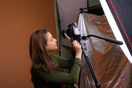 Young beautiful Indian woman vlogging against brown background