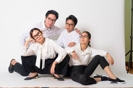 Group shot of Asian business people sitting on the floor togetherの写真素材
