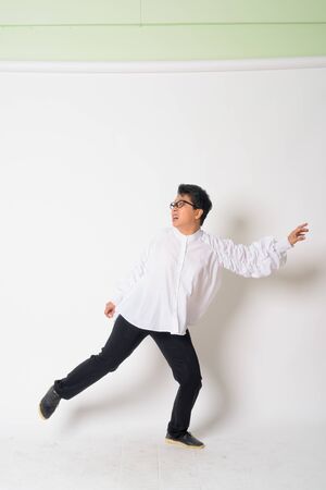 Portrait of mature Asian businesswoman with eyeglasses running awayの写真素材
