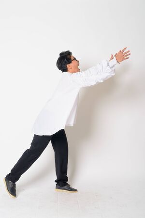 Portrait of mature Asian businesswoman with eyeglasses running awayの写真素材