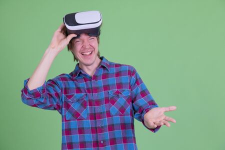 Happy young hipster man removing virtual reality headset and laughingの写真素材