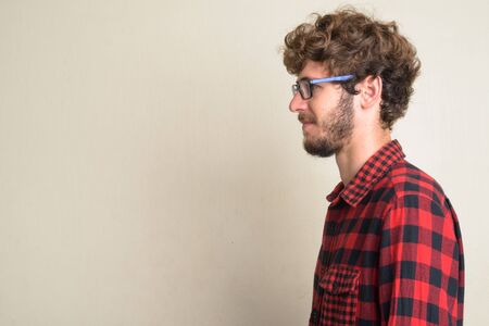 Closeup profile view of young bearded hipster man with curly hairの写真素材