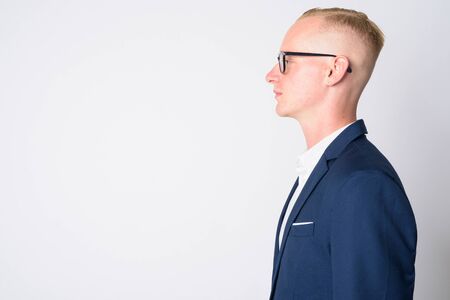 Closeup profile view of young blonde businessman in suit wearing eyeglassesの写真素材