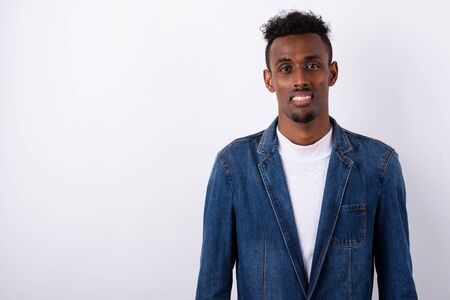 Young bearded African man wearing denim jacket against white bac