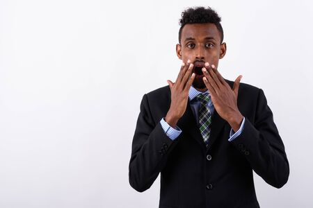 Young bearded African businessman wearing suit against white bac