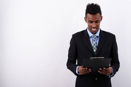 Young bearded African businessman wearing suit against white bac