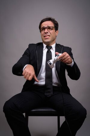 Portrait of Persian businessman in suit playing gamesの写真素材