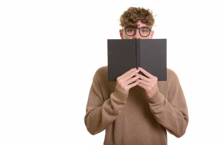 Studio shot of young handsome man with curly blond hair isolated against white backgroundの写真素材