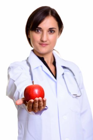Close up of beautiful woman doctor giving red appleの写真素材