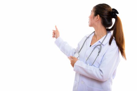 Portrait of young Asian woman doctor against white backgroundの写真素材