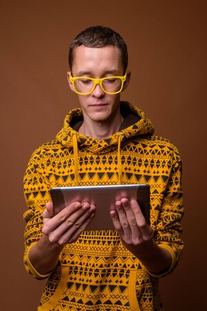 Studio shot of young man against brown backgroundの写真素材