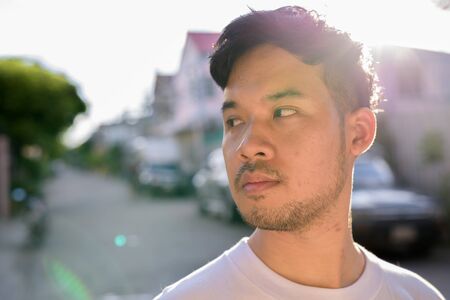 Young Asian man relaxing in the streets outdoorsの写真素材