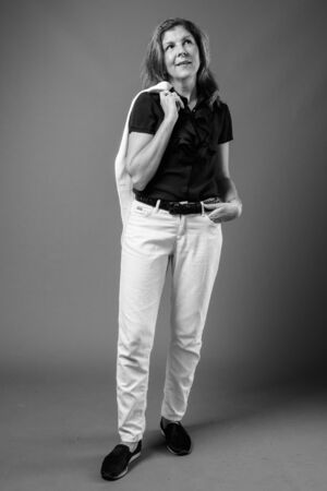 Studio shot of mature beautiful businesswoman in pantsuitの写真素材