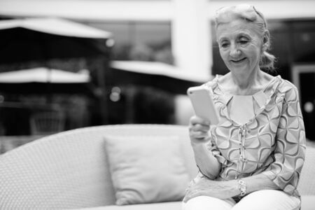 Beautiful senior tourist woman relaxing around the city in black and whiteの写真素材