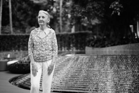 Beautiful senior tourist woman relaxing around the city in black and whiteの写真素材
