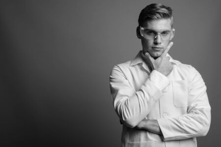 Portrait of young handsome man doctor as scientist in black and whiteの写真素材