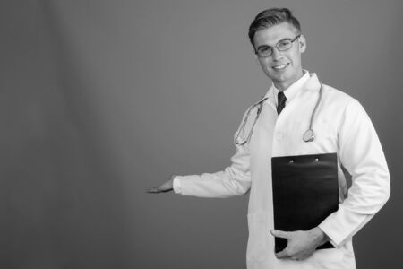 Portrait of young handsome man doctor with eyeglasses in black and whiteの写真素材