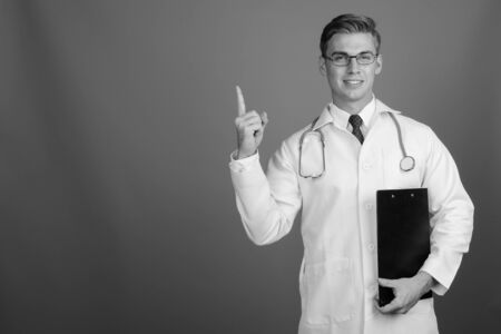 Portrait of young handsome man doctor with eyeglasses in black and whiteの写真素材