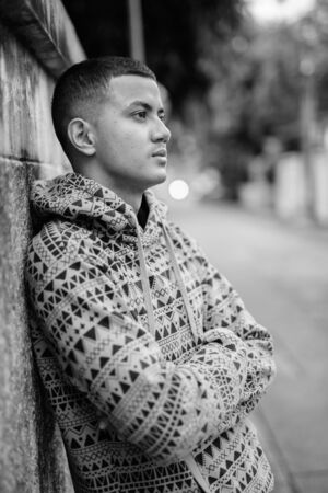 Young multi ethnic Asian man outdoors in black and whiteの写真素材