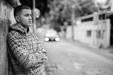 Young multi ethnic Asian man outdoors in black and whiteの写真素材