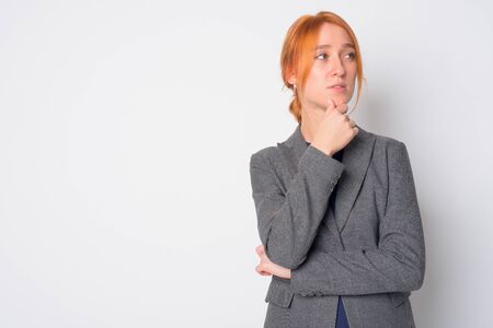 Portrait of young beautiful redhead businesswoman thinkingの写真素材