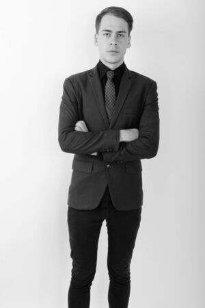 Portrait of young handsome businessman wearing suit in black and whiteの写真素材