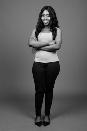 Young beautiful African woman against gray backgroundの写真素材