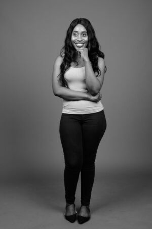 Young beautiful African woman against gray backgroundの写真素材