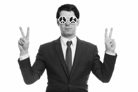 Handsome businessman wearing sunglasses with peace sign and doing peace sign with both handsの写真素材