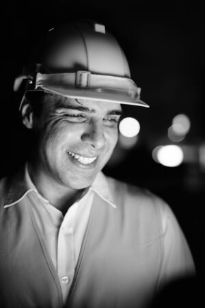 Handsome Persian man construction worker at the construction site at nightの写真素材