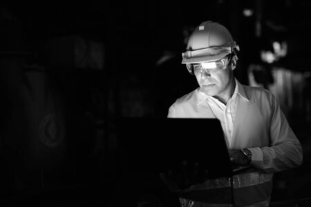Handsome Persian man construction worker at the construction site at night