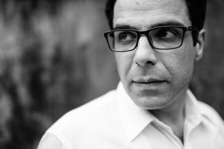 Handsome Persian businessman against concrete wall outdoorsの写真素材