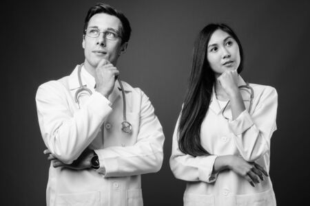 Portrait of two young multi ethnic doctors together in black and whiteの写真素材
