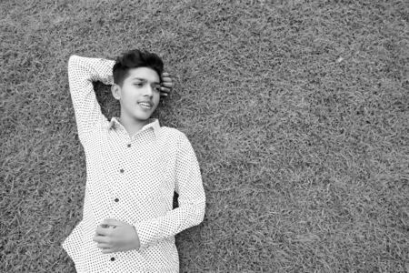Portrait of young Indian teenage boy relaxing at the parkの写真素材