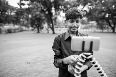 Portrait of young Indian boy relaxing at the parkの写真素材