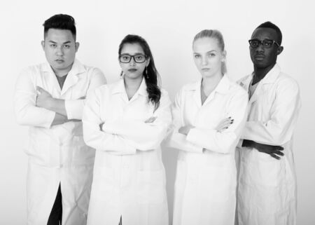 Studio shot of diverse group of multi ethnic doctors with arms crossed togetherの写真素材