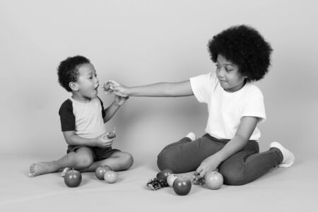 Young cute African siblings together in black and whiteの写真素材
