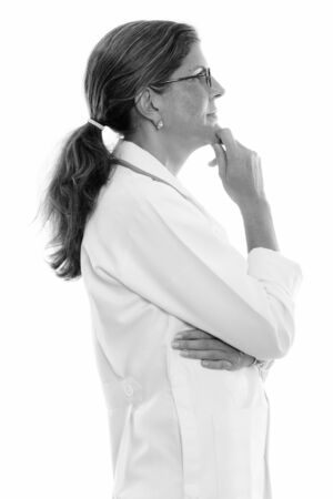 Profile view of mature beautiful woman doctor thinkingの写真素材