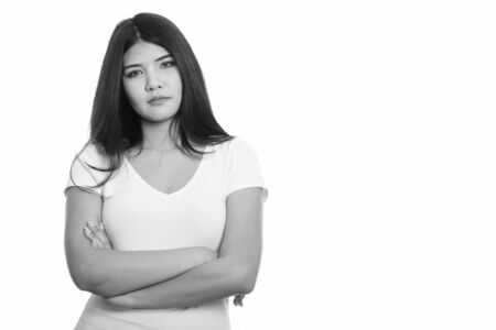 Studio shot of young Asian woman with arms crossedの写真素材