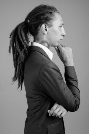 Young businessman with dreadlocks wearing suit in black and whiteの写真素材