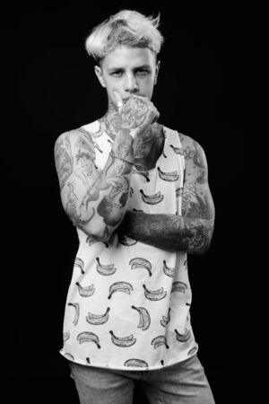 Young handsome rebellious man with blond hair in black and whiteの写真素材