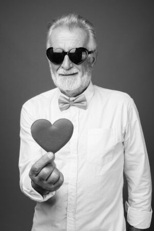 Handsome bearded senior man wearing stylish clothes in black and whiteの写真素材